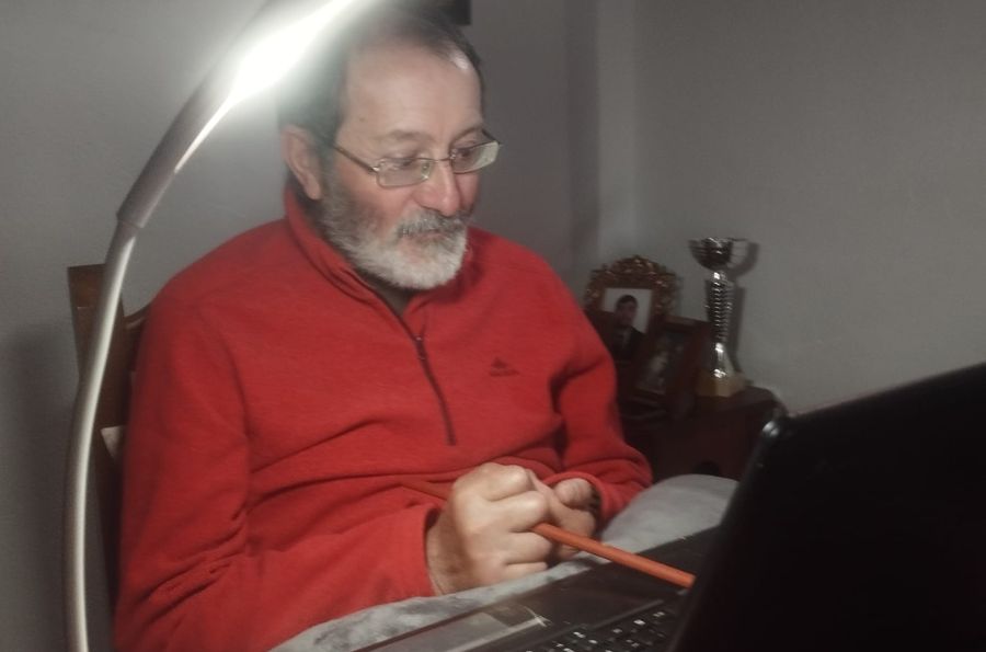 Hombre escribiendo con un palo en el ordenador