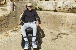 Hombre en silla de ruedas delante de una fuente