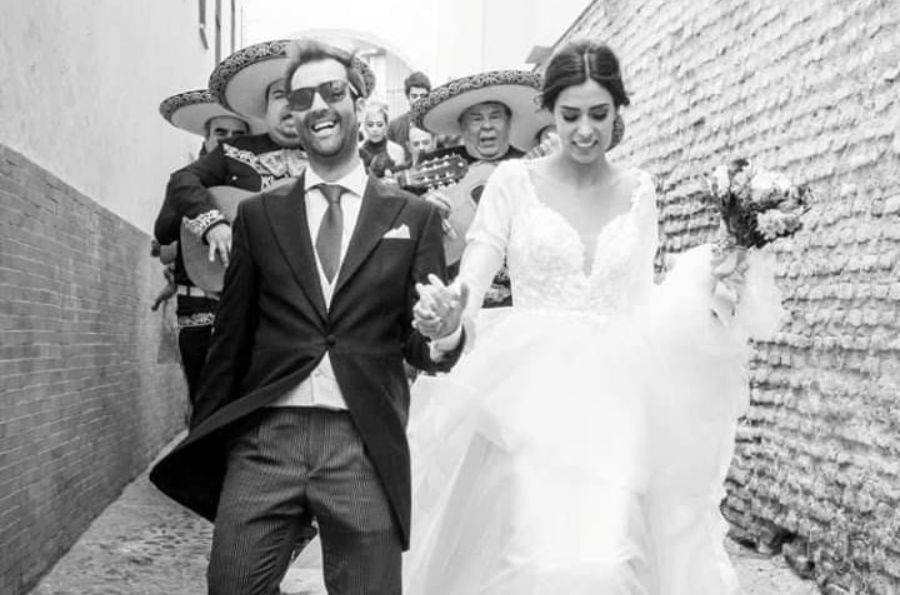 Novios con mariachi detrás