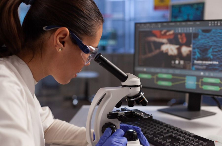 Investigadora en laboratorio mirando por el microscopio
