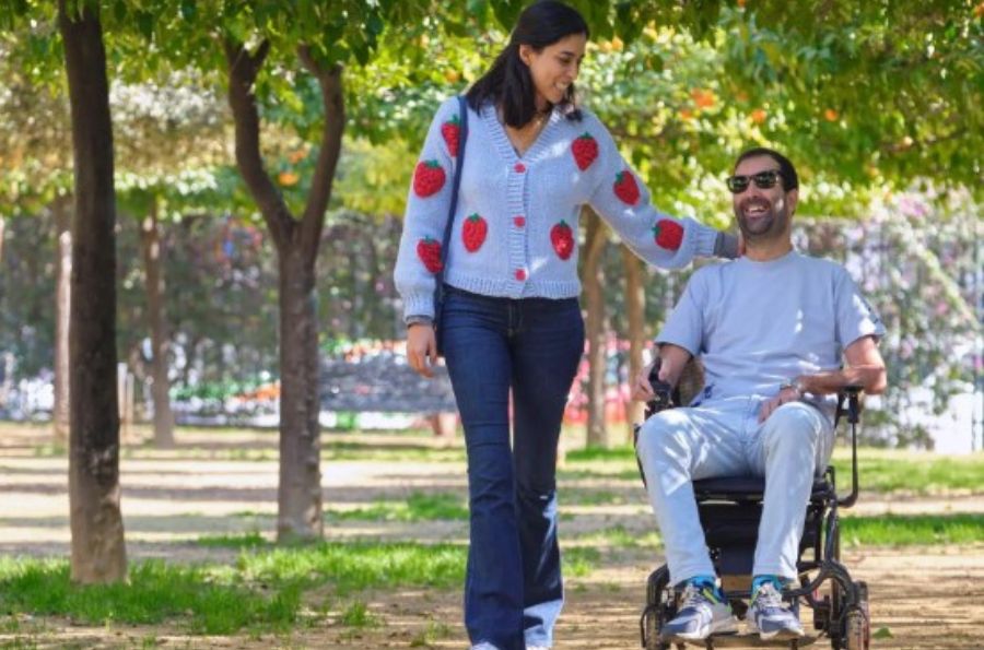 Hombre en silla de ruedas de paseo con mujer