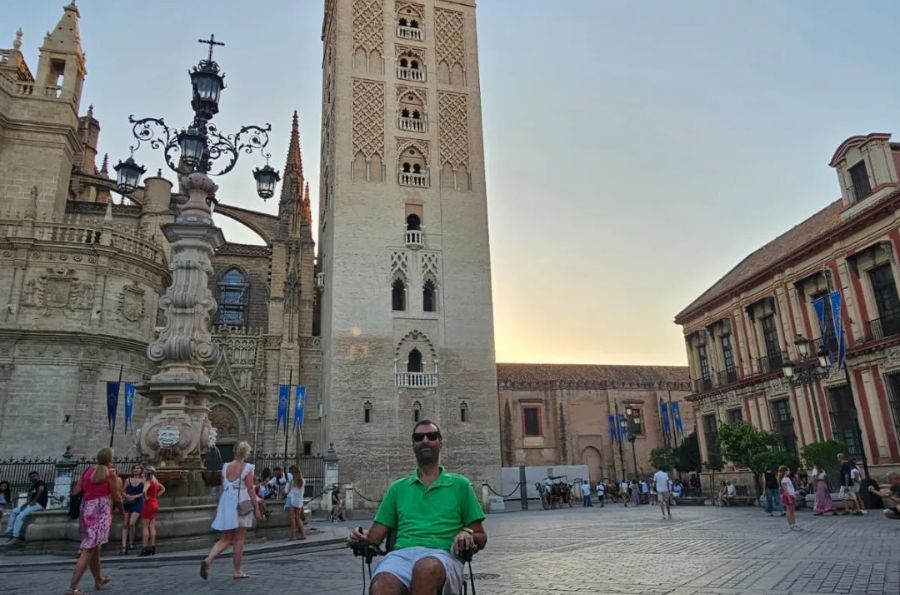 Pepe posando en silla de ruedas delante de la Giralda