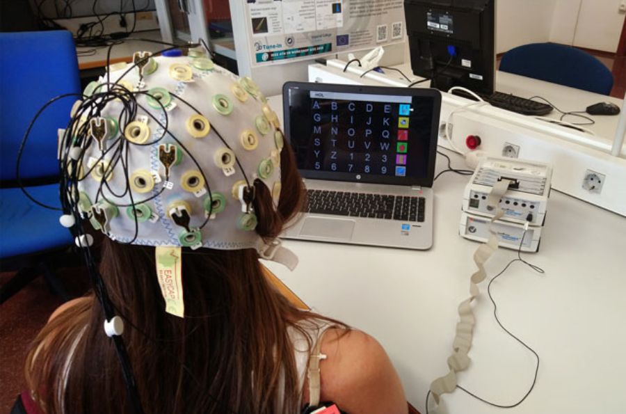 Persona con cables en la cabeza para la comunicación cerebral