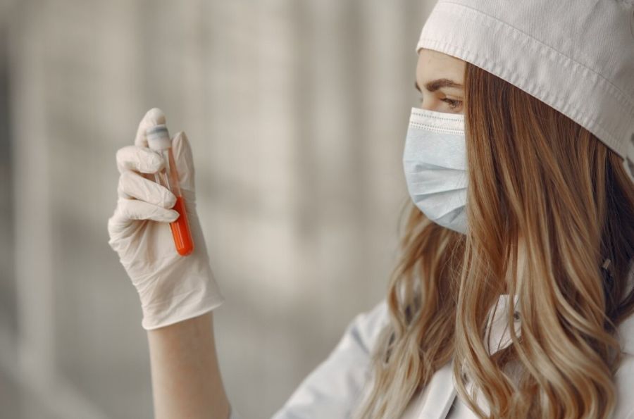 Mujer con tubo de muestras biológicas en la mano