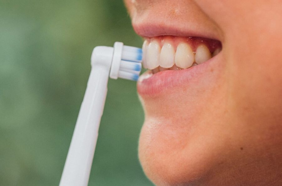 Boca con cepillo de dientes eléctrico