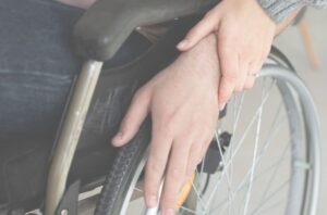 manos en una rueda de una silla de ruedas